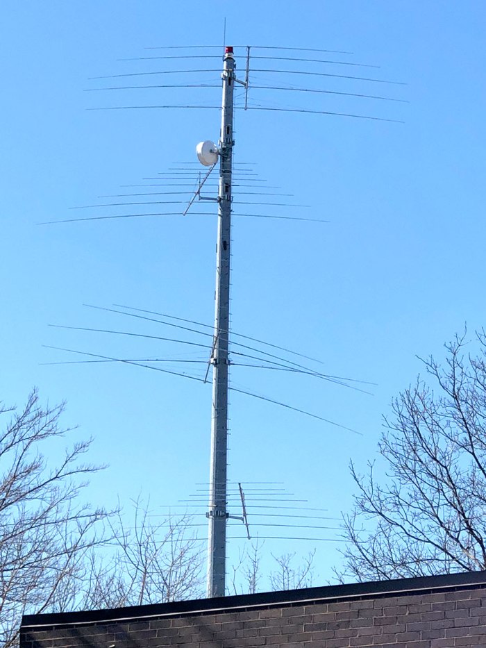 Una foto de una torre celular con múltiples niveles de antenas que sobresalen de ella.